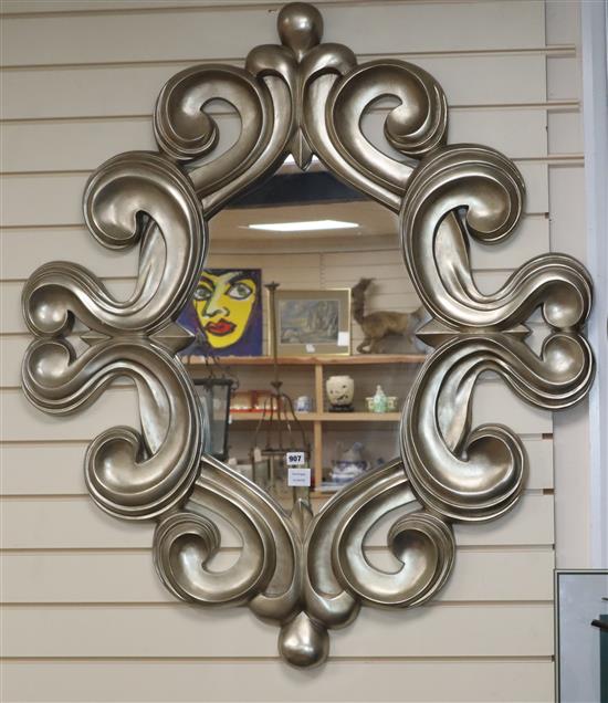 A silvered scroll framed mirror, with a shaped oval plate H.120cm